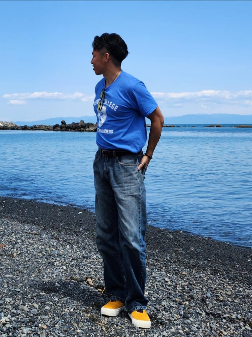 ブルー系のTシャツ/カットソー、ブルー系のデニムパンツ、イエロー系のスニーカーを着用したメンズの春コーディネートの2枚目の写真