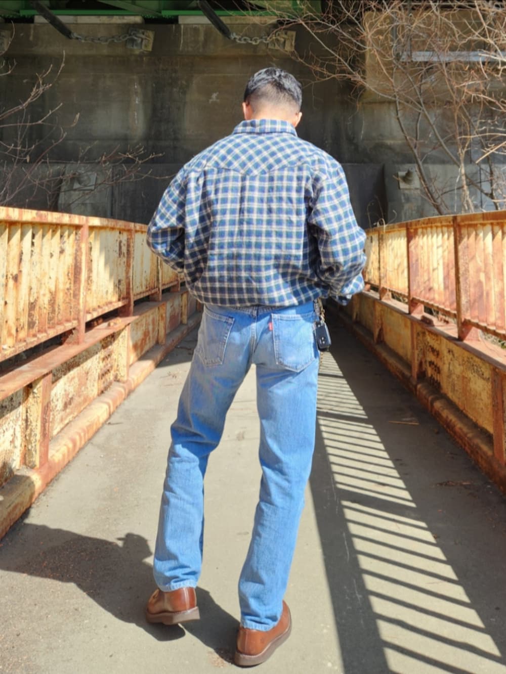 グリーン系のシャツ/ブラウス、ブルー系のデニムパンツ、ブラウン系のブーツを着用したメンズの春コーディネートの3枚目の写真