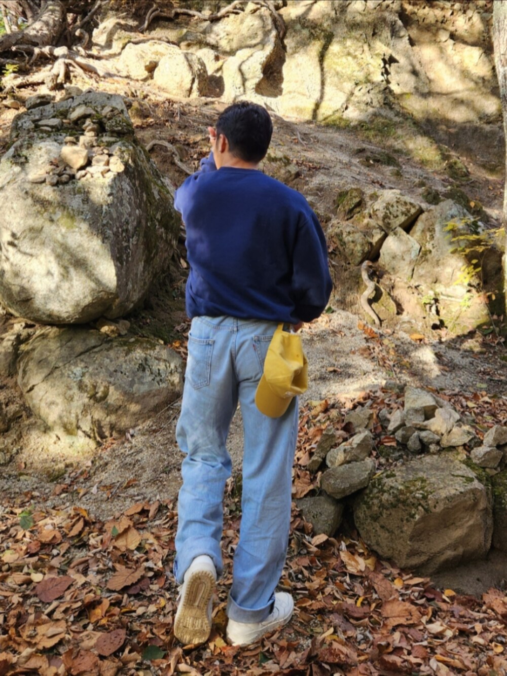 ブルー系のスウェット、ブルー系のデニムパンツ、ホワイト系のスニーカーを着用したメンズの秋コーディネートの2枚目の写真