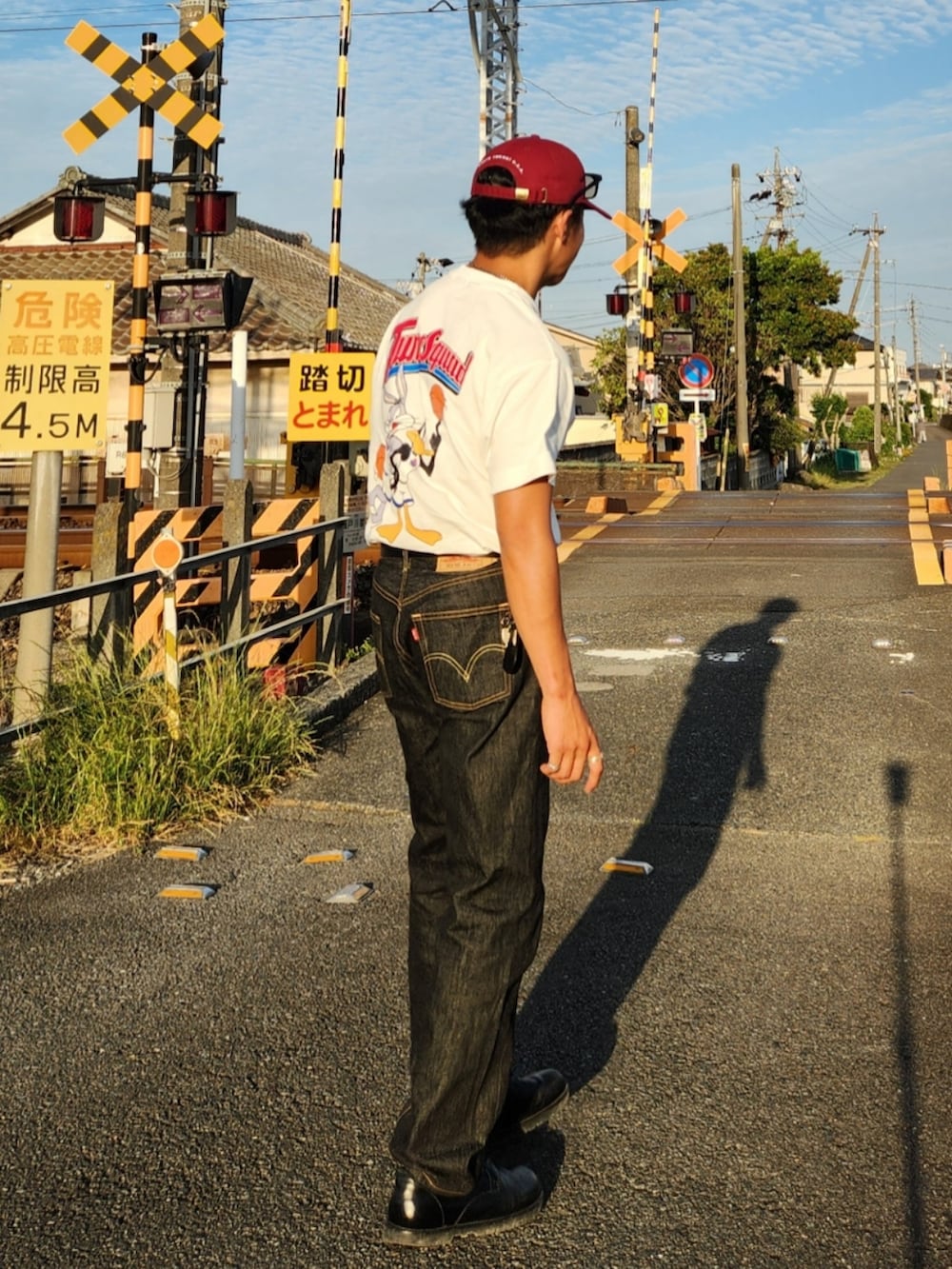 ホワイト系のTシャツ/カットソー、ブラック系のデニムパンツ、ブラック系のブーツを着用したメンズの春コーディネートの4枚目の写真