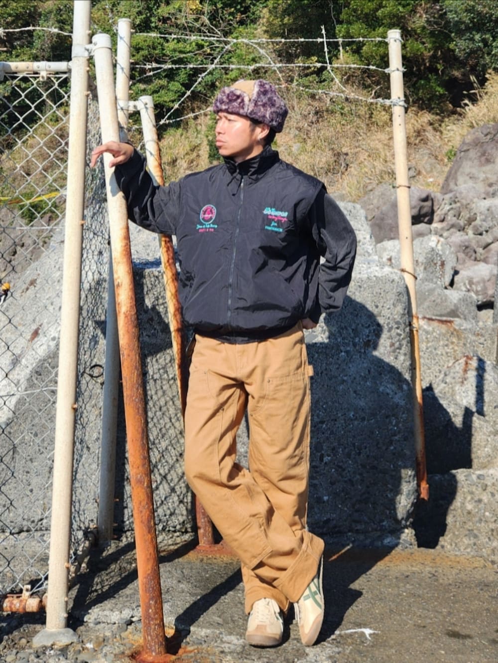 ブラック系のベスト、グレー系のスウェット、ブラウン系のパンツを着用したメンズの秋コーディネートの3枚目の写真