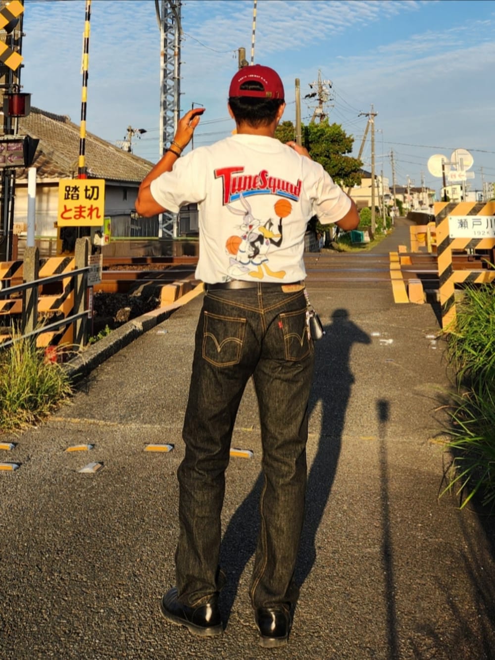 ホワイト系のTシャツ/カットソー、ブラック系のデニムパンツ、ブラック系のブーツを着用したメンズの春コーディネートの5枚目の写真
