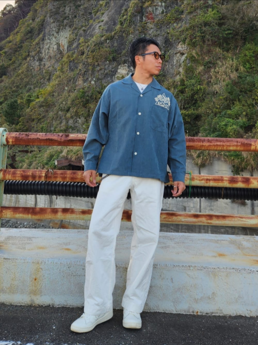 グリーン系のシャツ/ブラウス、ホワイト系のパンツ、ホワイト系のスニーカーを着用したメンズの秋コーディネートの2枚目の写真