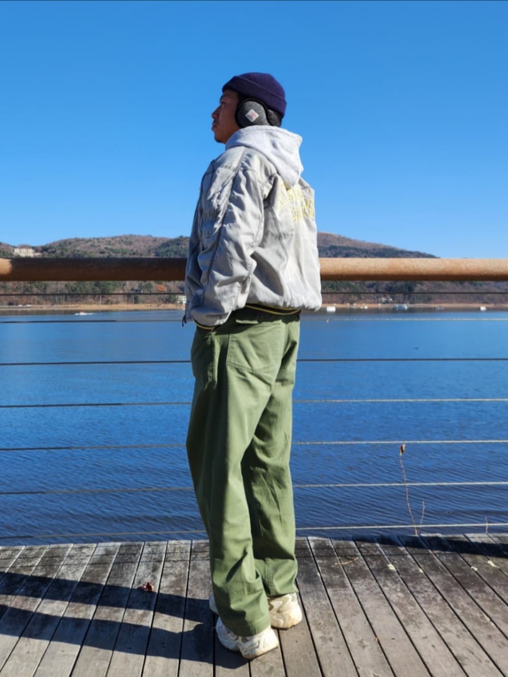 シルバー系のスタジャン、グレー系のパーカー、グリーン系のカーゴパンツを着用したメンズの秋コーディネートの2枚目の写真