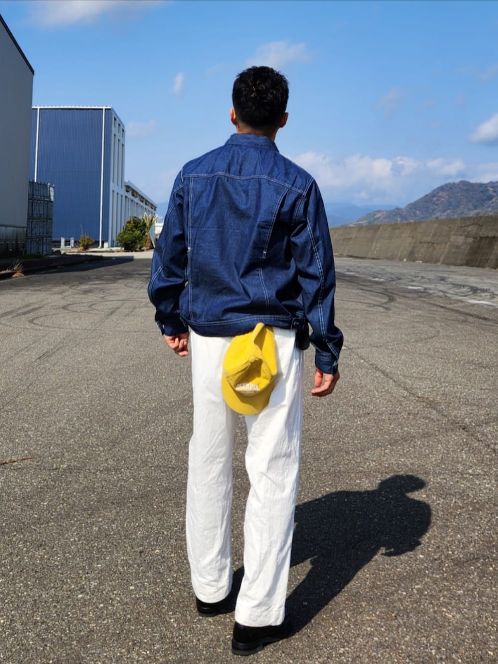 ホワイト系のパンツ、ブラック系のローファー、ブルー系のデニムジャケットを着用したメンズの冬コーディネートの4枚目の写真