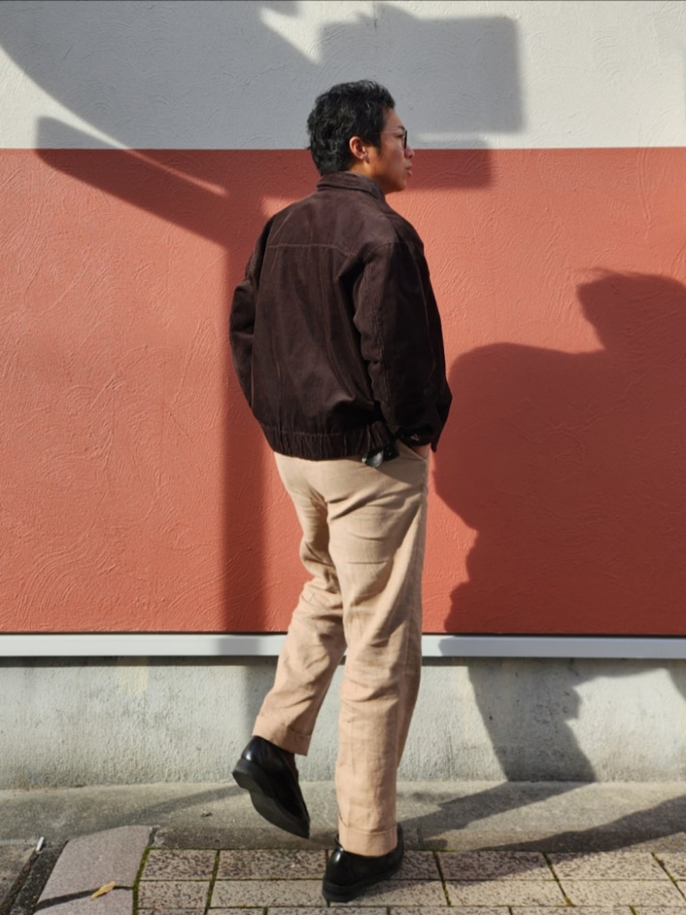 ブラック系のジャケット/アウター、ブラウン系のその他トップス、ベージュ系のスラックスを着用したメンズの冬コーディネートの2枚目の写真