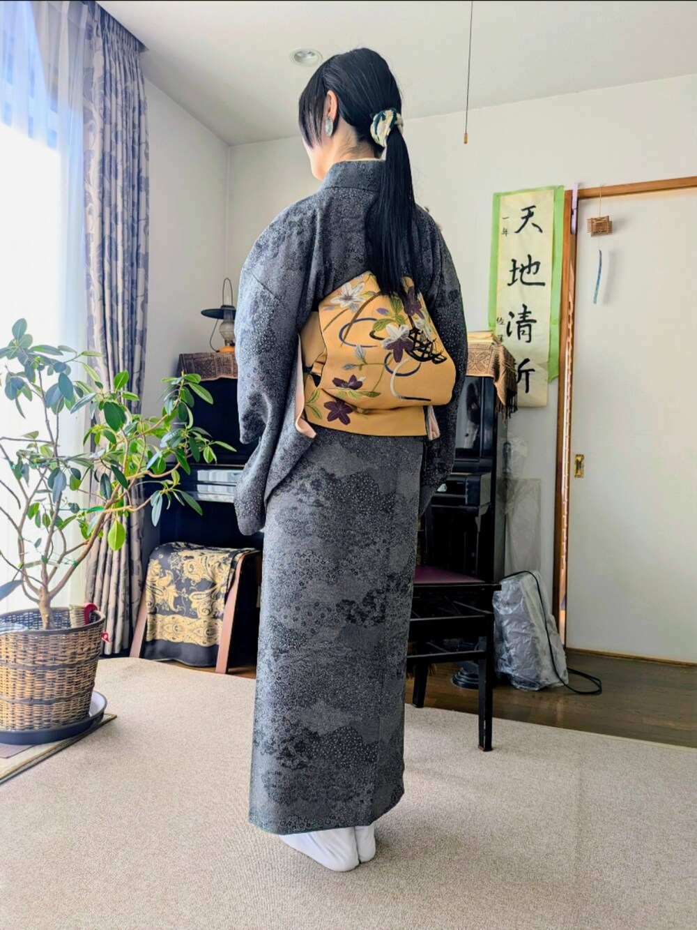 グレー系の着物、イエロー系の和装小物を着用したレディースの冬コーディネートの2枚目の写真