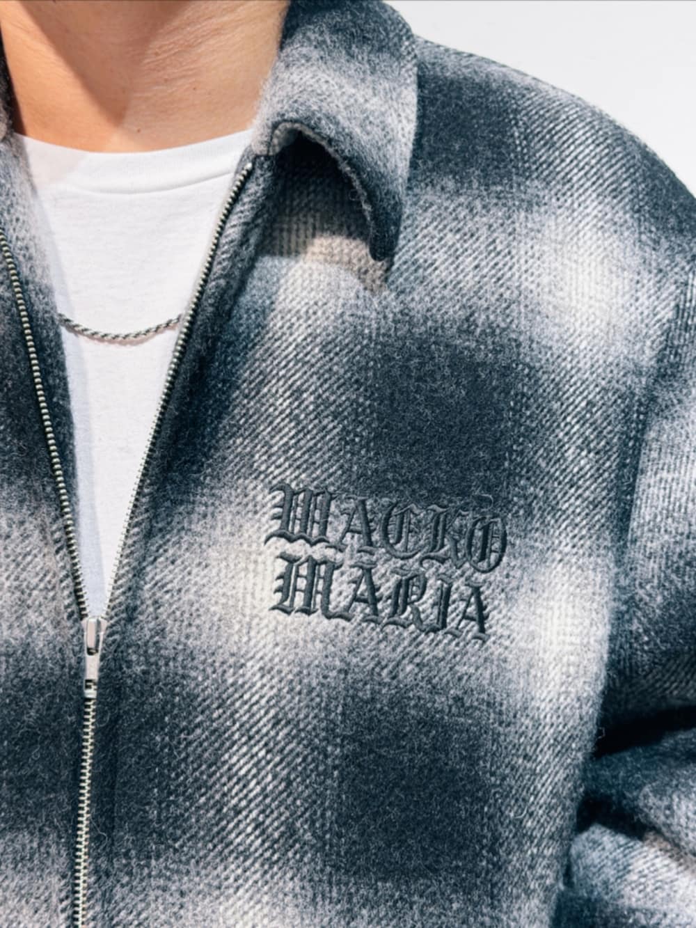 ブラック系のその他アウター、ブラック系のチノパンツ、ブラック系のスニーカーを着用したメンズの秋コーディネートの3枚目の写真