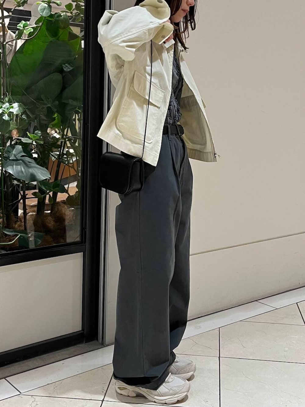 ブラック系のショルダーバッグ、グレー系のその他パンツ、ホワイト系のブルゾンを着用したレディースの春コーディネートの3枚目の写真