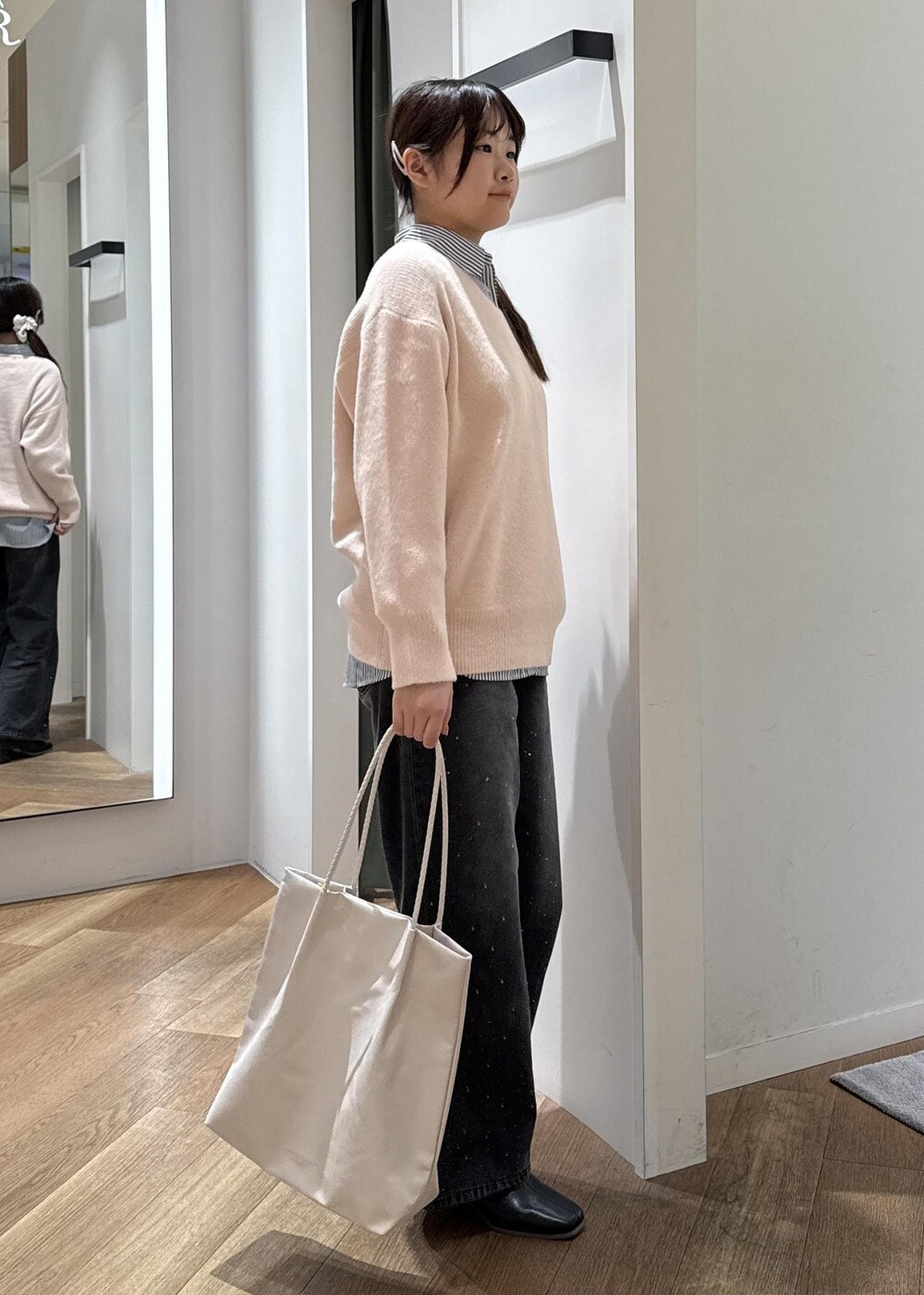 ホワイト系のトートバッグ、ブラック系のデニムパンツ、ブルー系のシャツ/ブラウスを着用したレディースの秋コーディネートの4枚目の写真