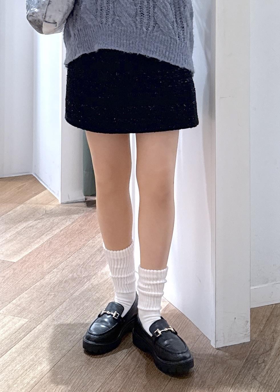 ブルー系のスカート、ホワイト系のTシャツ/カットソー、ブルー系のニット/セーターを着用したレディースの冬コーディネートの3枚目の写真