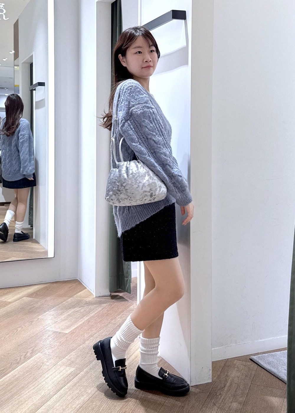 ブルー系のスカート、ホワイト系のTシャツ/カットソー、ブルー系のニット/セーターを着用したレディースの冬コーディネートの4枚目の写真