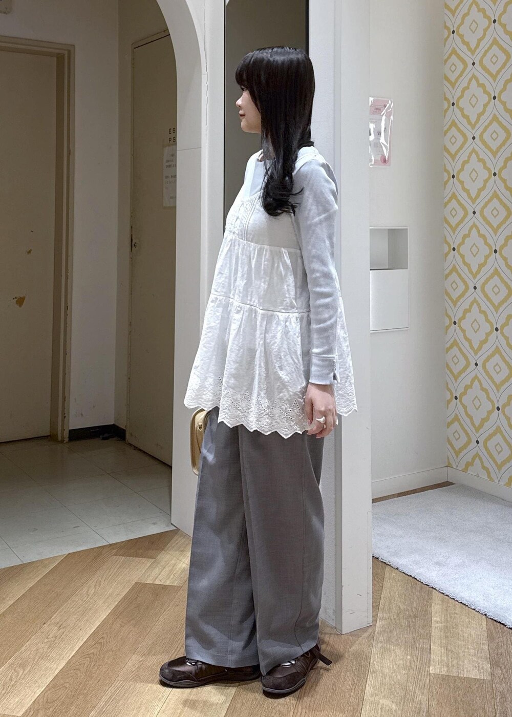 ベージュ系のボストンバッグ、ブルー系のTシャツ/カットソー、ホワイト系のキャミソールを着用したレディースの春コーディネートの6枚目の写真