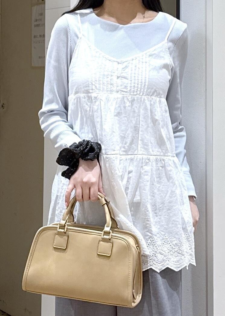 ベージュ系のボストンバッグ、ブルー系のTシャツ/カットソー、ホワイト系のキャミソールを着用したレディースの春コーディネートの2枚目の写真