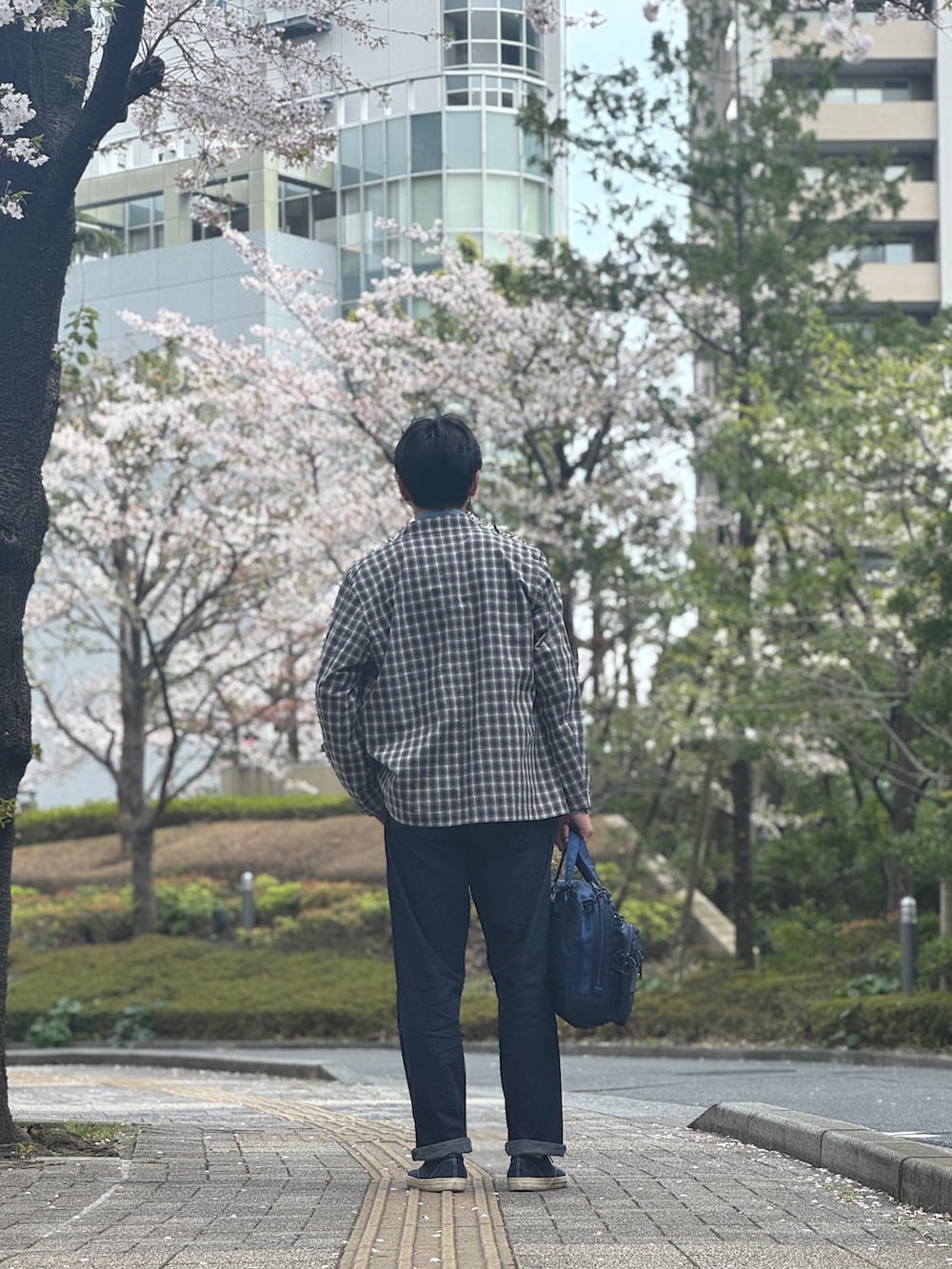 ブラック系のその他アウター、ブルー系のスニーカー、ブルー系のデニムパンツを着用したメンズの夏コーディネートの3枚目の写真