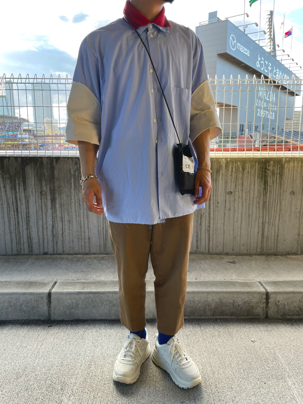 ブルー系のシャツ/ブラウス、ブラウン系のパンツ、ホワイト系のスニーカーを着用したメンズの夏コーディネートの2枚目の写真