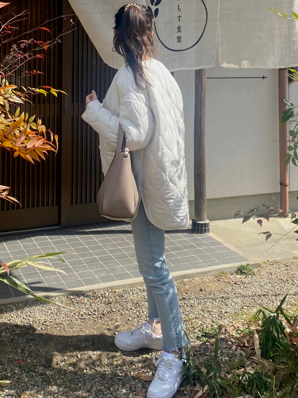 ベージュ系のバッグ、ホワイト系のジャケット/アウター、ホワイト系のスニーカーを着用したレディースの春コーディネートの2枚目の写真