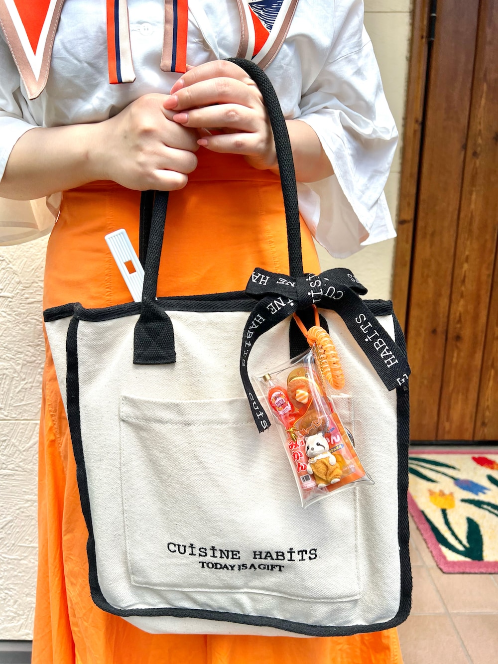 ホワイト系のトートバッグ、ホワイト系のシャツ/ブラウス、オレンジ系のスカートを着用したレディースの秋コーディネートの3枚目の写真