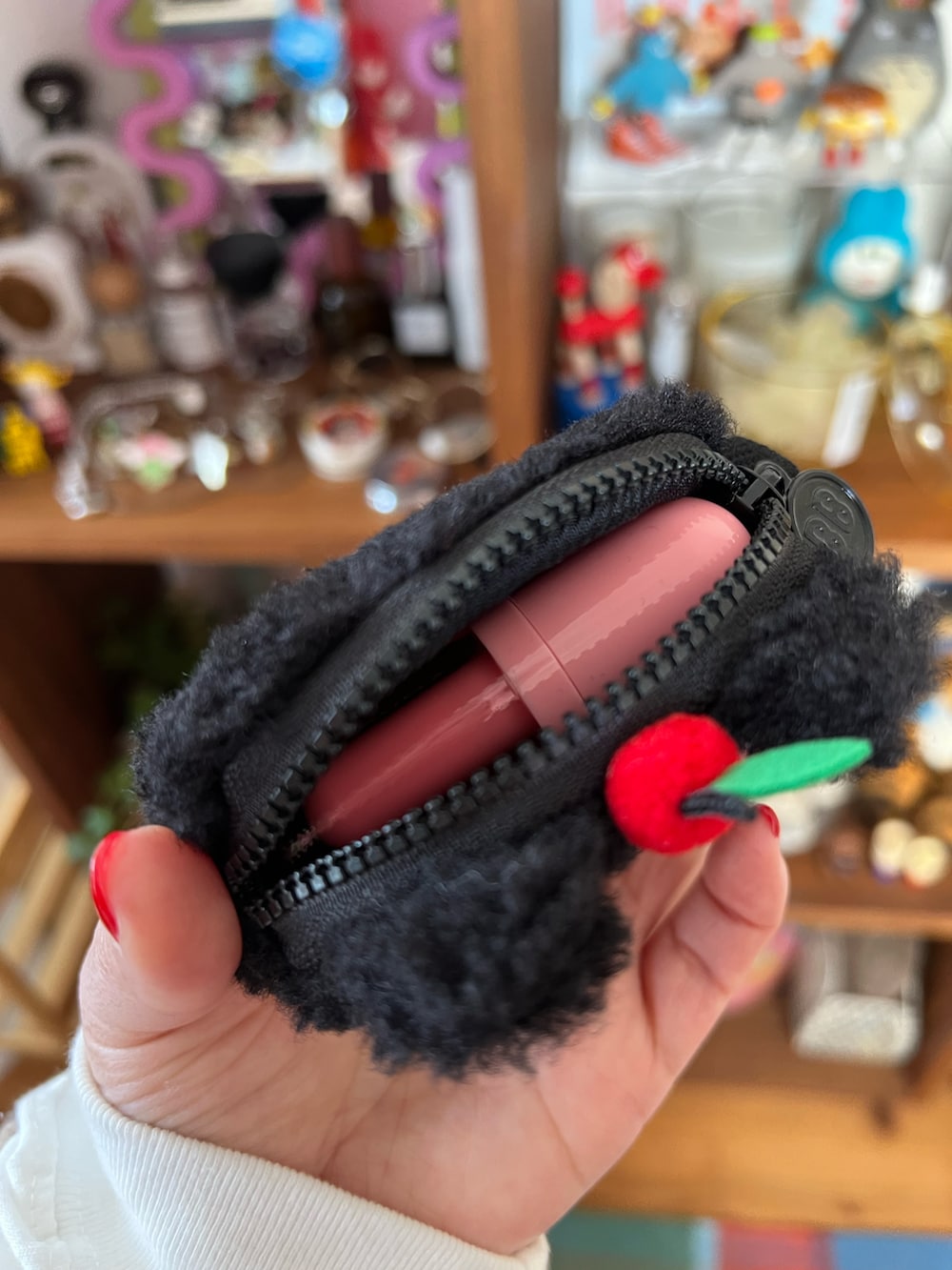 ブラック系のチャーム、ブラック系のスマホグッズ、ピンク系のポーチを着用したレディースの春コーディネートの3枚目の写真