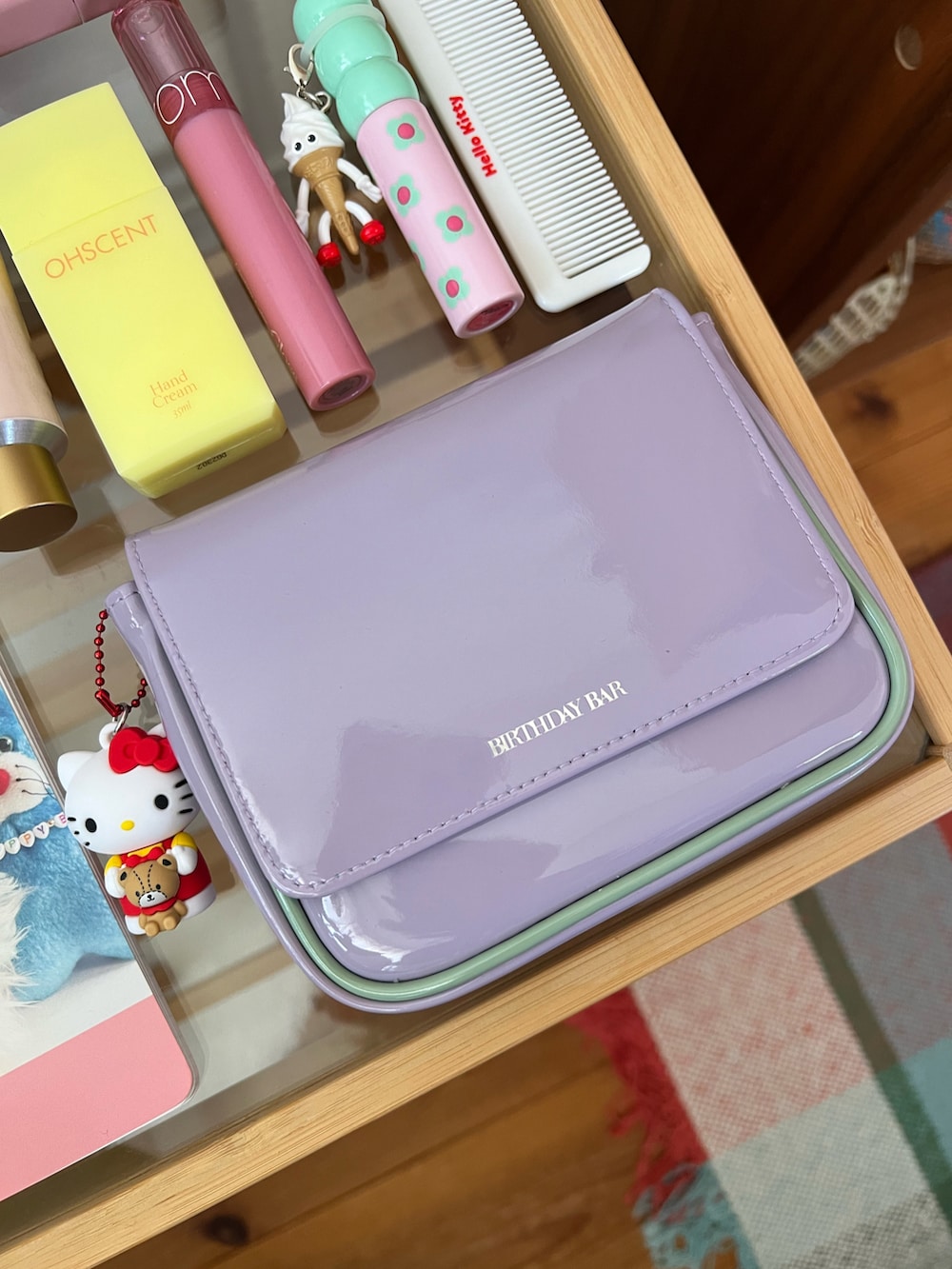 パープル系のポーチ、ピンク系の香水、イエロー系のハンドケア/ハンドクリームを着用したレディースの秋コーディネートの3枚目の写真