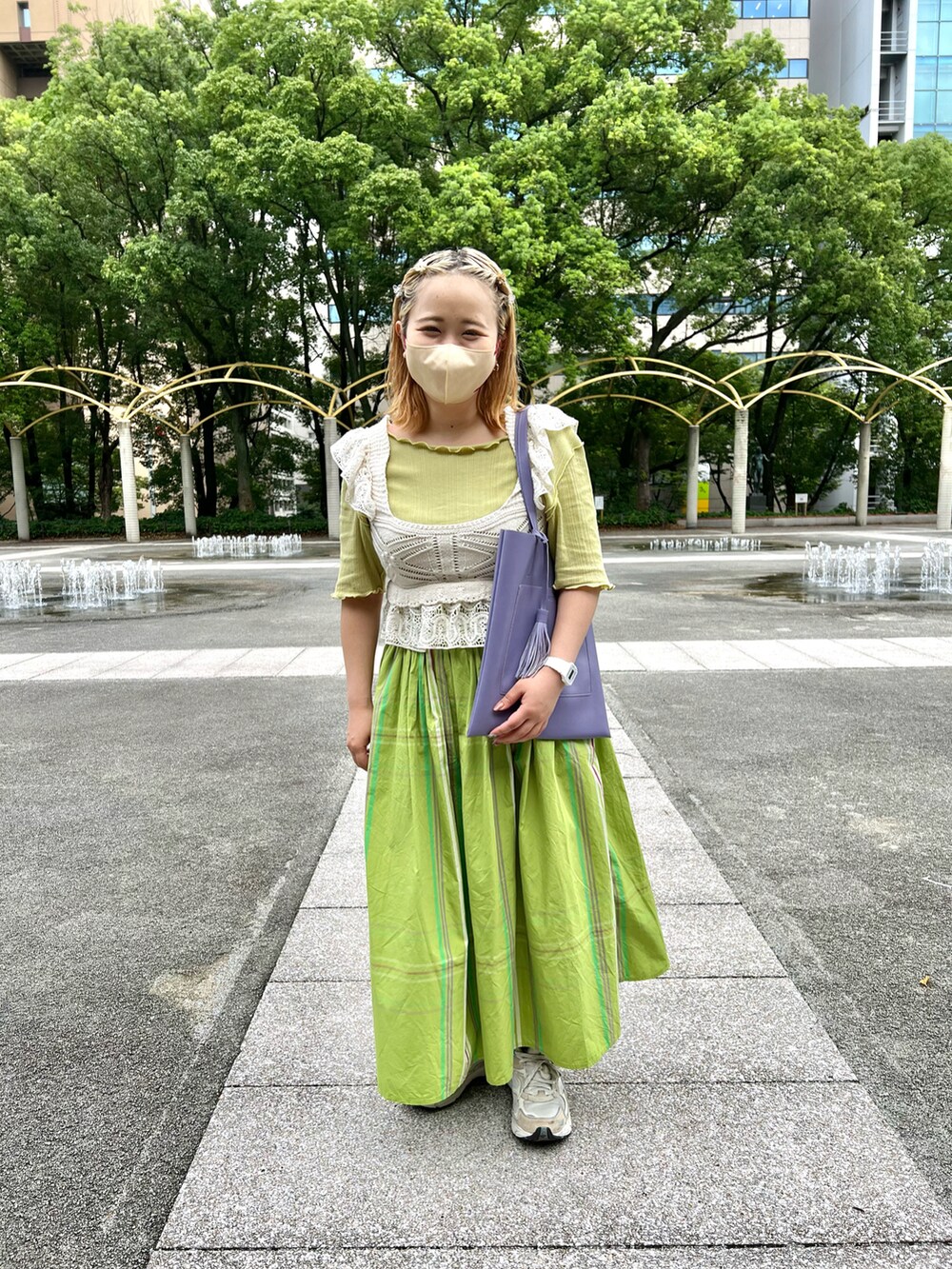 パープル系のトートバッグ、グリーン系のスカート、ホワイト系のトップスを着用したレディースの秋コーディネートの2枚目の写真