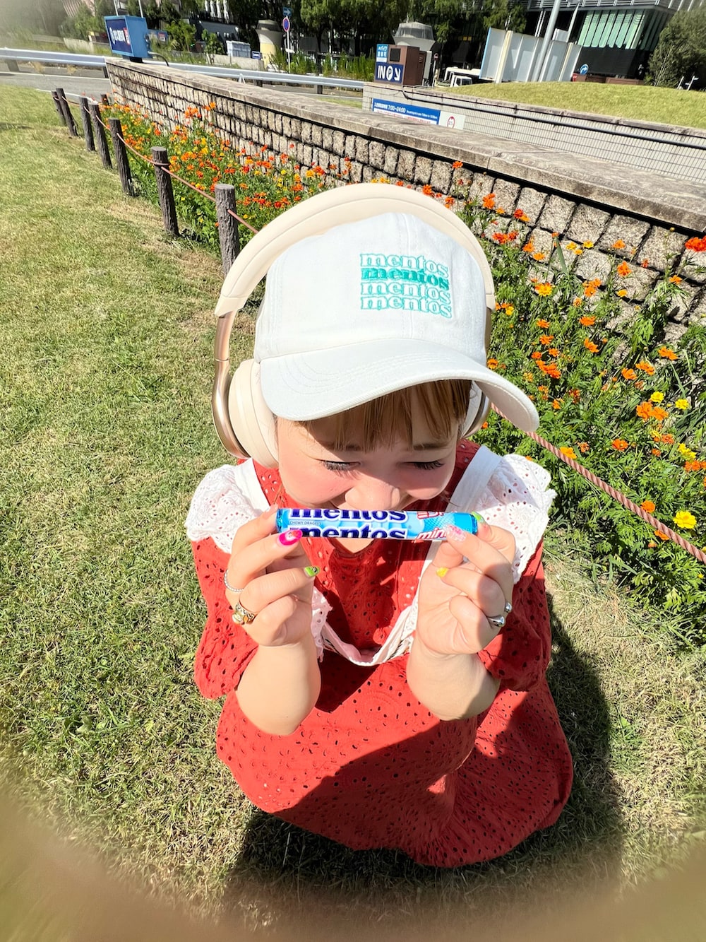 シルバー系のトートバッグ、オレンジ系のワンピース、ホワイト系のスニーカーを着用したレディースの夏コーディネートの3枚目の写真