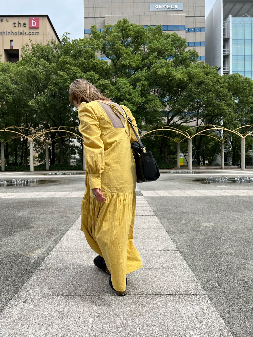 ブラック系のトートバッグ、イエロー系のワンピースを着用したレディースの秋コーディネートの3枚目の写真