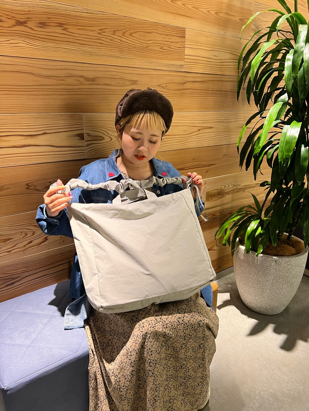 グレー系のトートバッグ、ブルー系のシャツ/ブラウス、ベージュ系のワンピースを着用したレディースの冬コーディネートの5枚目の写真