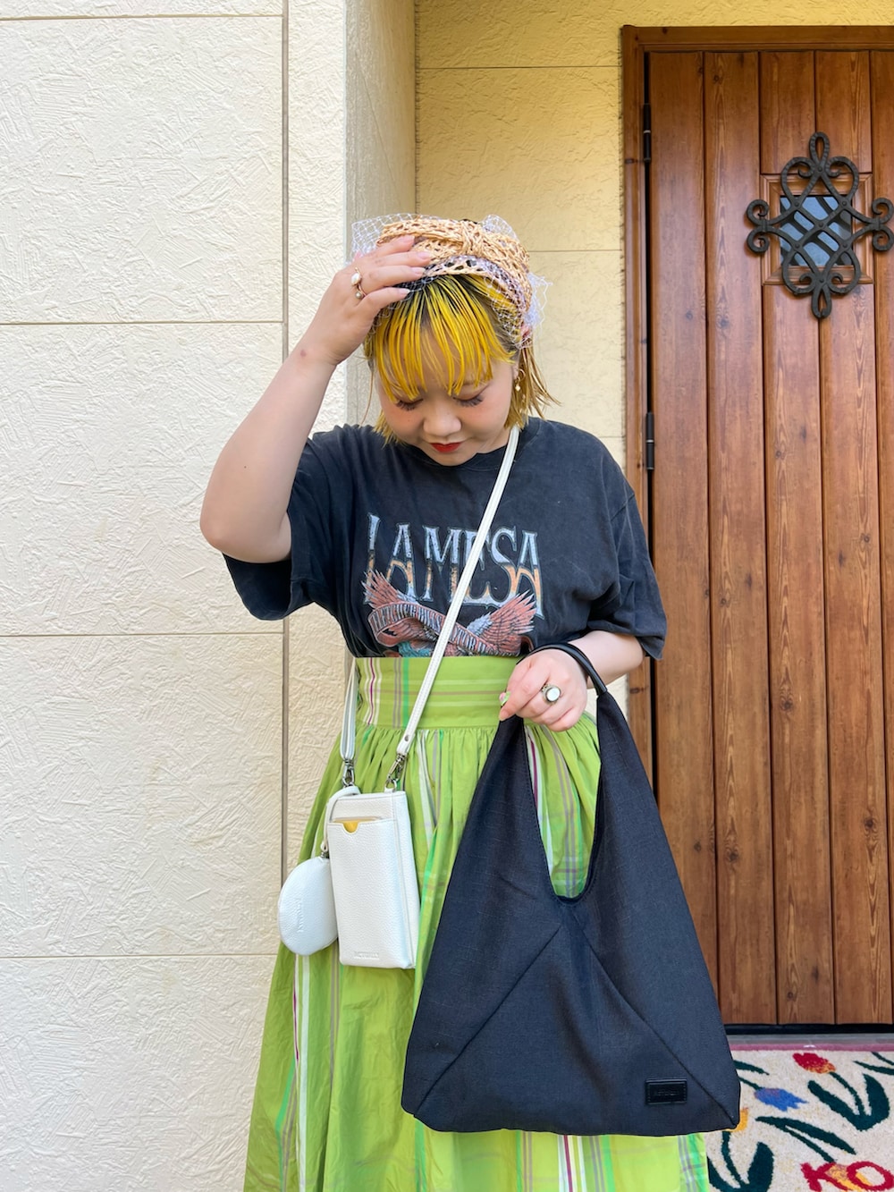 ブラック系のトートバッグ、ホワイト系のショルダーバッグ、ブラック系のTシャツ/カットソーを着用したレディースの夏コーディネートの3枚目の写真