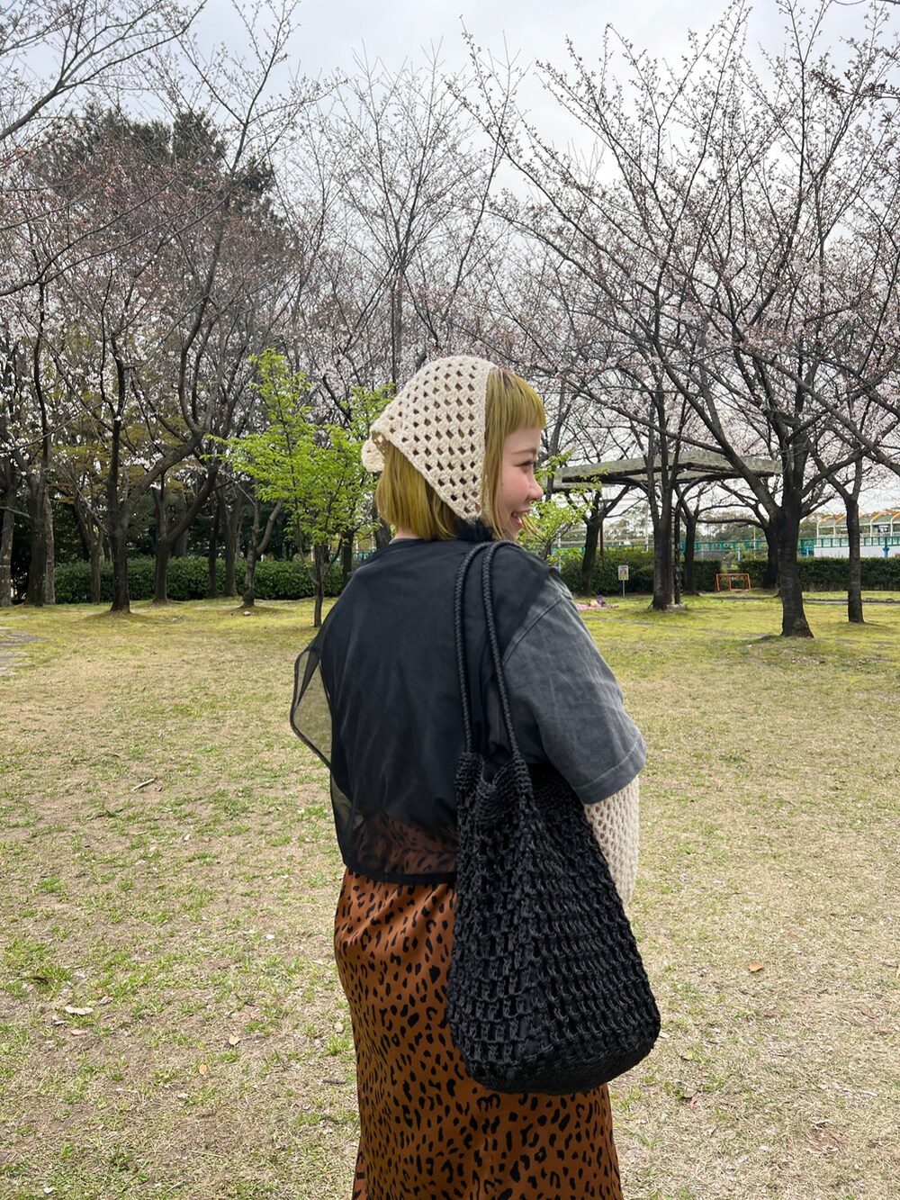 ブラック系のトートバッグ、ブラック系のTシャツ/カットソー、ホワイト系のニット/セーターを着用したレディースの春コーディネートの3枚目の写真