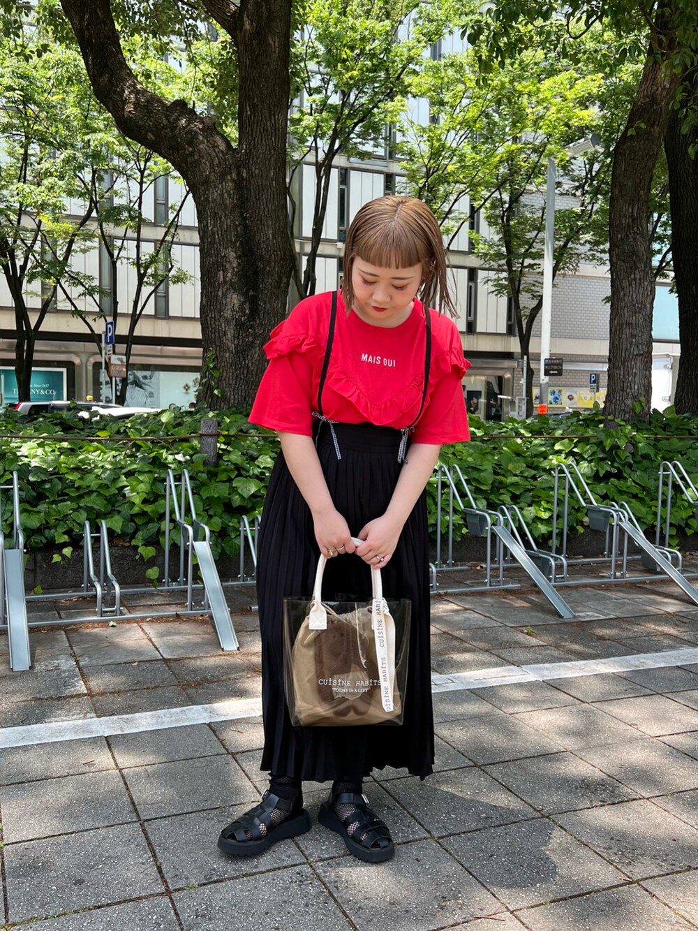 ホワイト系のトートバッグ、レッド系のTシャツ/カットソー、ブラック系のスカートを着用したレディースの夏コーディネートの2枚目の写真