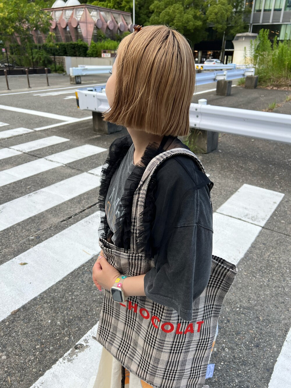 ブラック系のトートバッグ、ホワイト系のスカート、オレンジ系のスニーカーを着用したレディースの夏コーディネートの2枚目の写真