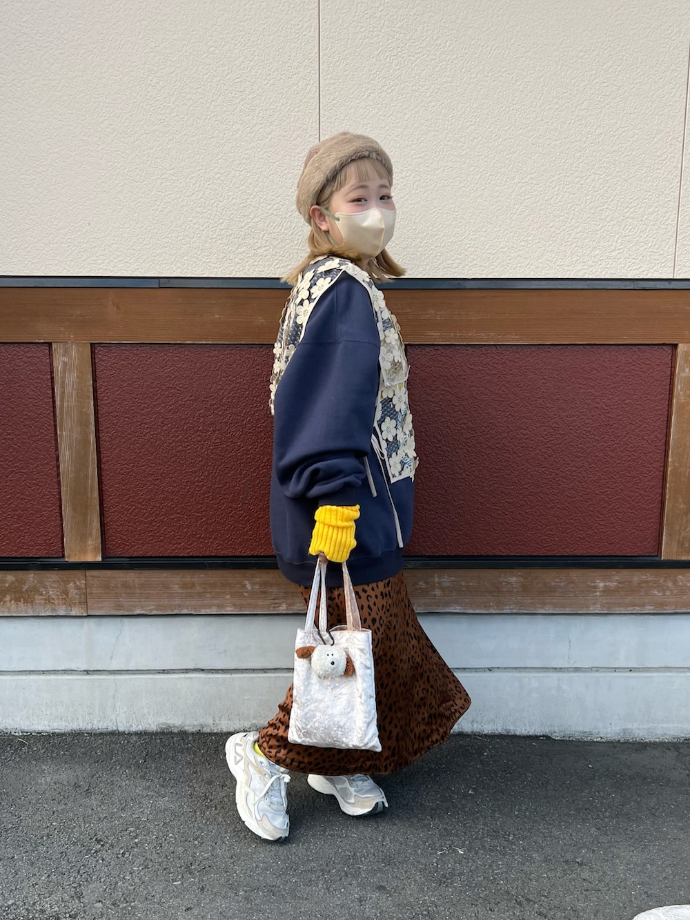 ベージュ系のハンドバッグ、ブルー系のスウェット、ベージュ系のベストを着用したレディースの冬コーディネートの2枚目の写真