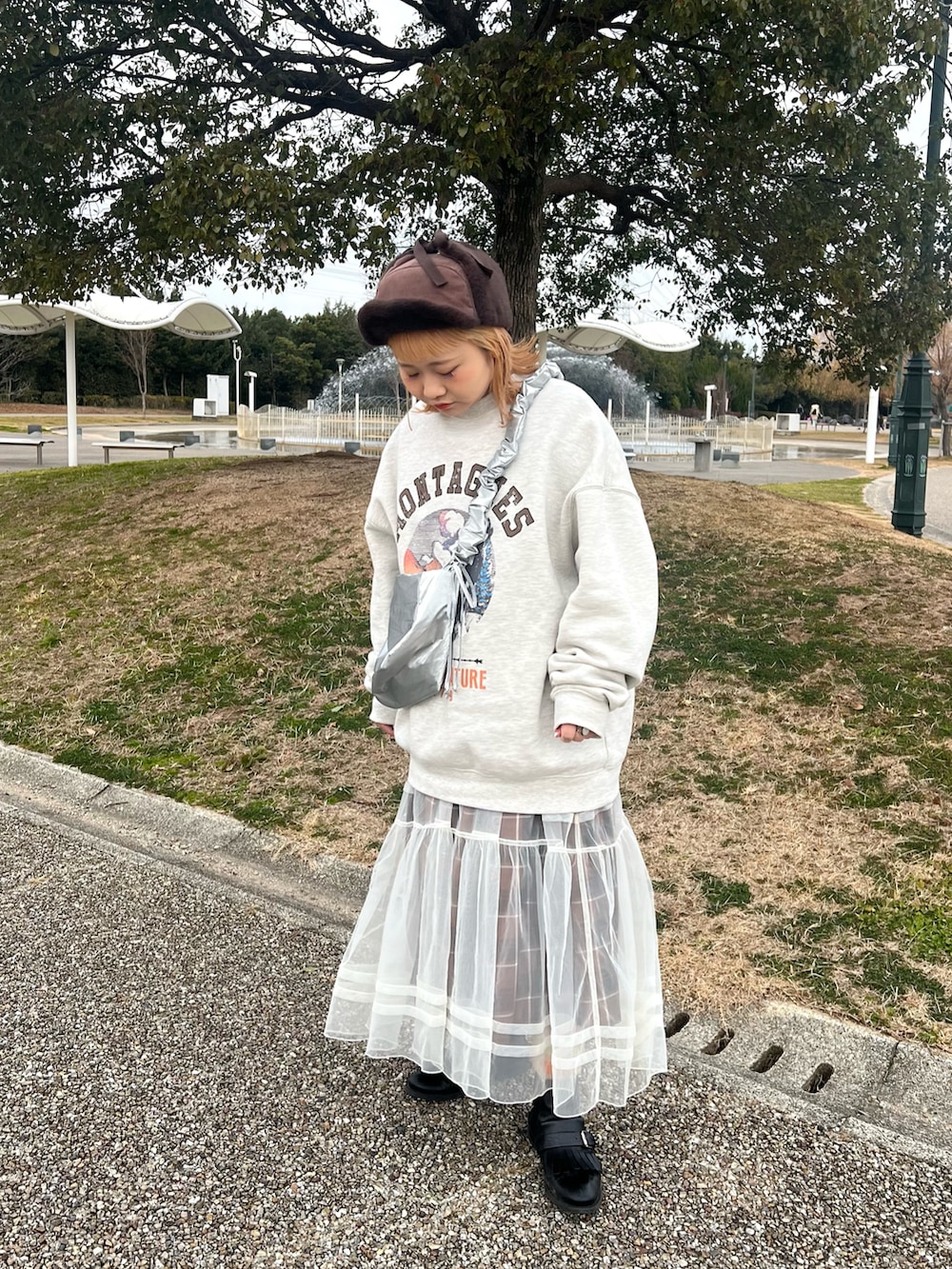 シルバー系のショルダーバッグ、ベージュ系のスウェット、ホワイト系のワンピースを着用したレディースの冬コーディネートの2枚目の写真