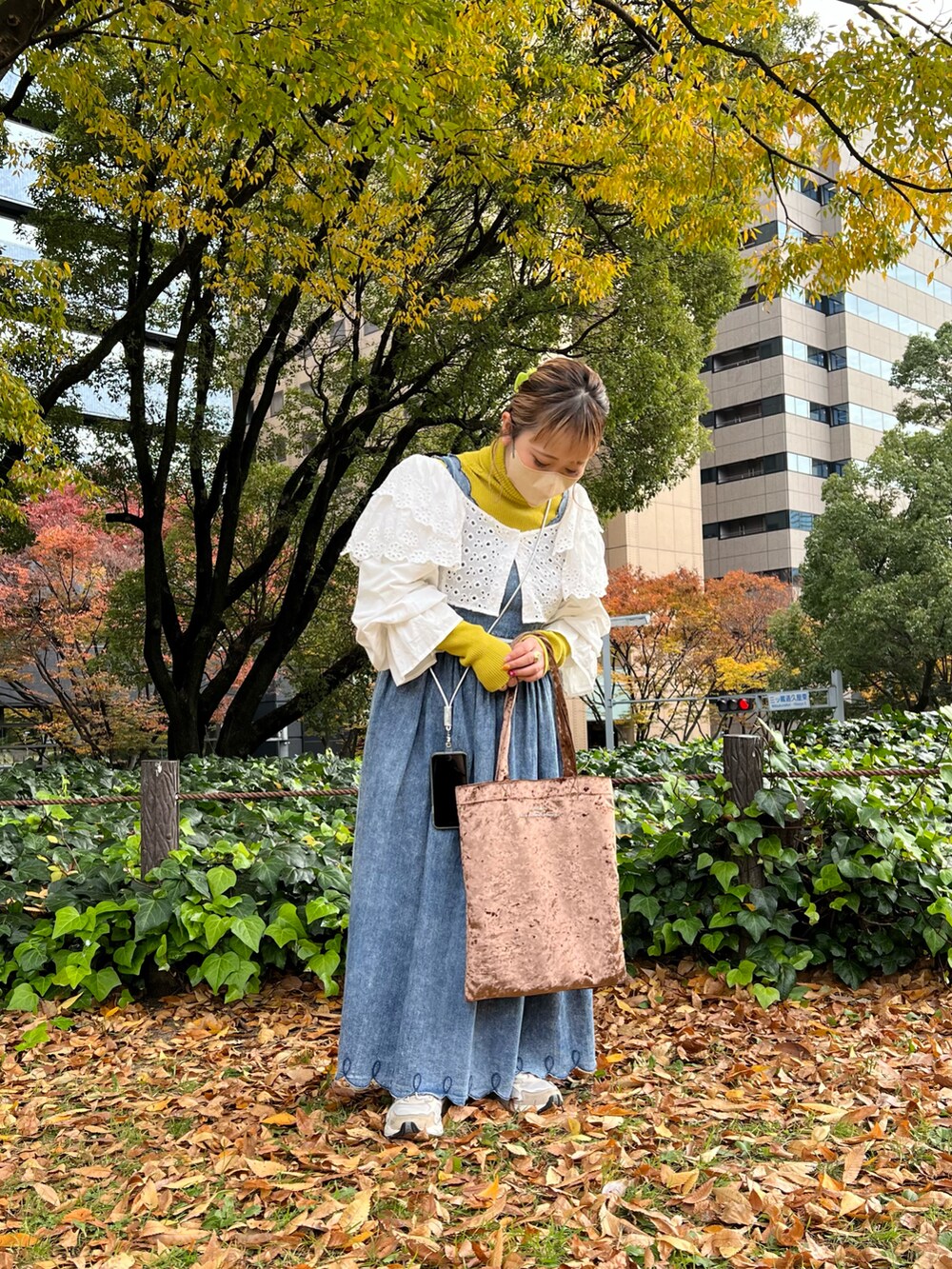 ブラウン系のエコバッグ/サブバッグ、ホワイト系のカーディガン/ボレロ、イエロー系のニット/セーターを着用したレディースの冬コーディネートの2枚目の写真