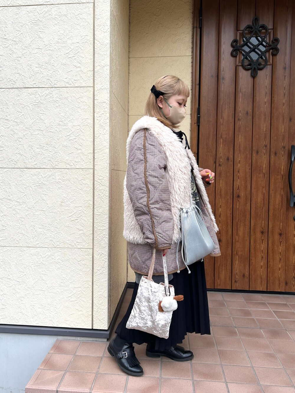 シルバー系のショルダーバッグ、ベージュ系のハンドバッグ、ホワイト系のダウンジャケット/コートを着用したレディースの冬コーディネートの2枚目の写真