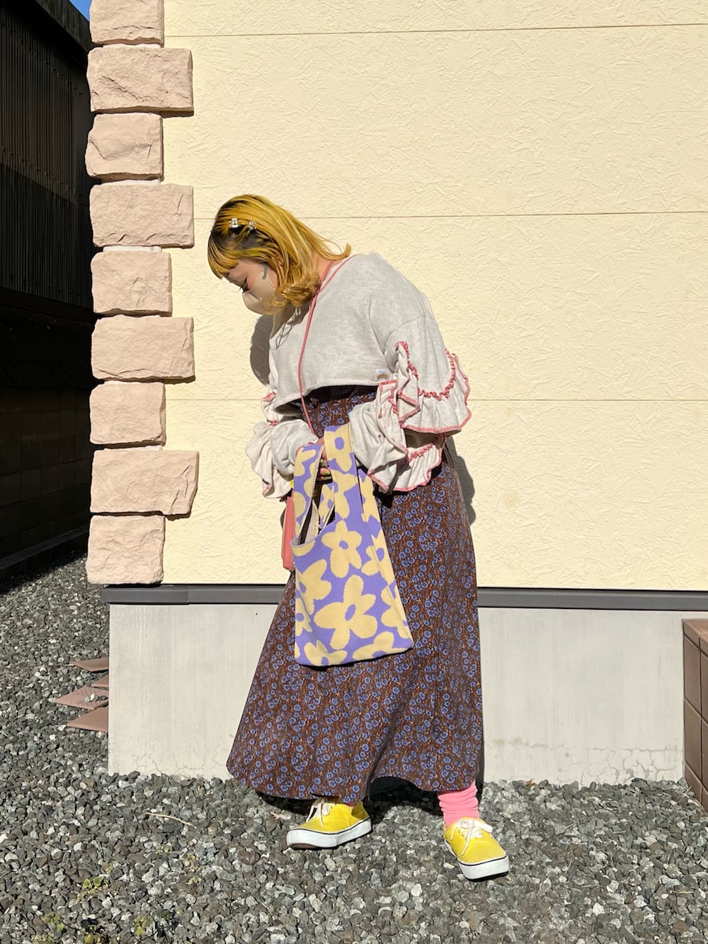 ピンク系のショルダーバッグ、グレー系のスウェット、ブラウン系のワンピースを着用したレディースの冬コーディネートの2枚目の写真