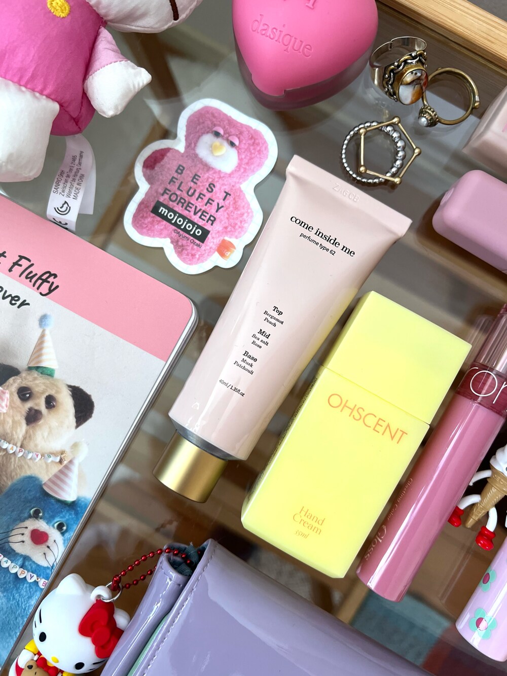 パープル系のポーチ、ピンク系の香水、イエロー系のハンドケア/ハンドクリームを着用したレディースの秋コーディネートの2枚目の写真