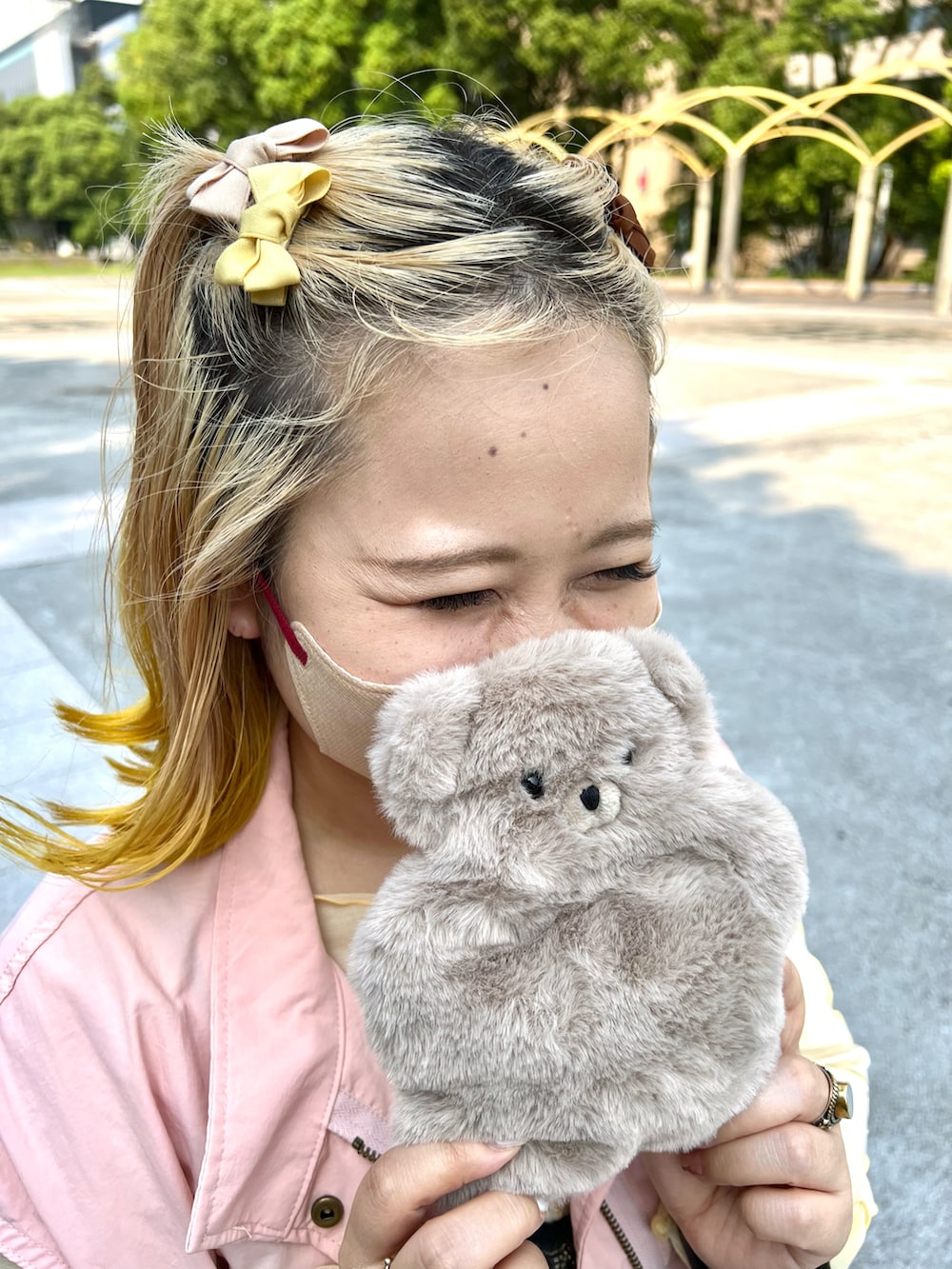 ホワイト系のショルダーバッグ、ピンク系のベスト、イエロー系のTシャツ/カットソーを着用したレディースの秋コーディネートの4枚目の写真