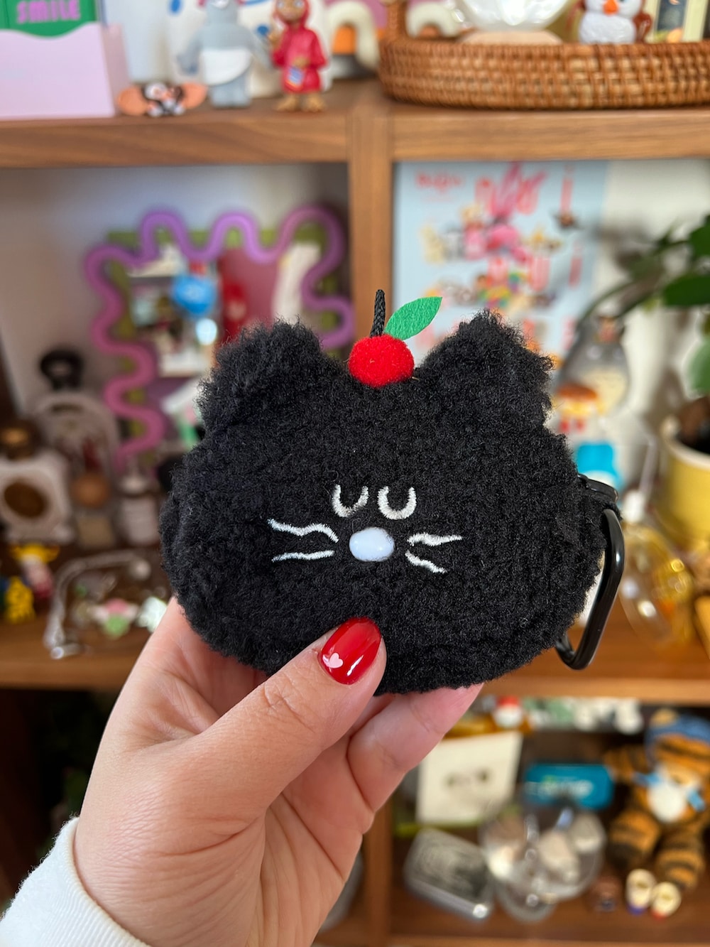 ブラック系のチャーム、ブラック系のスマホグッズ、ピンク系のポーチを着用したレディースの春コーディネートの2枚目の写真