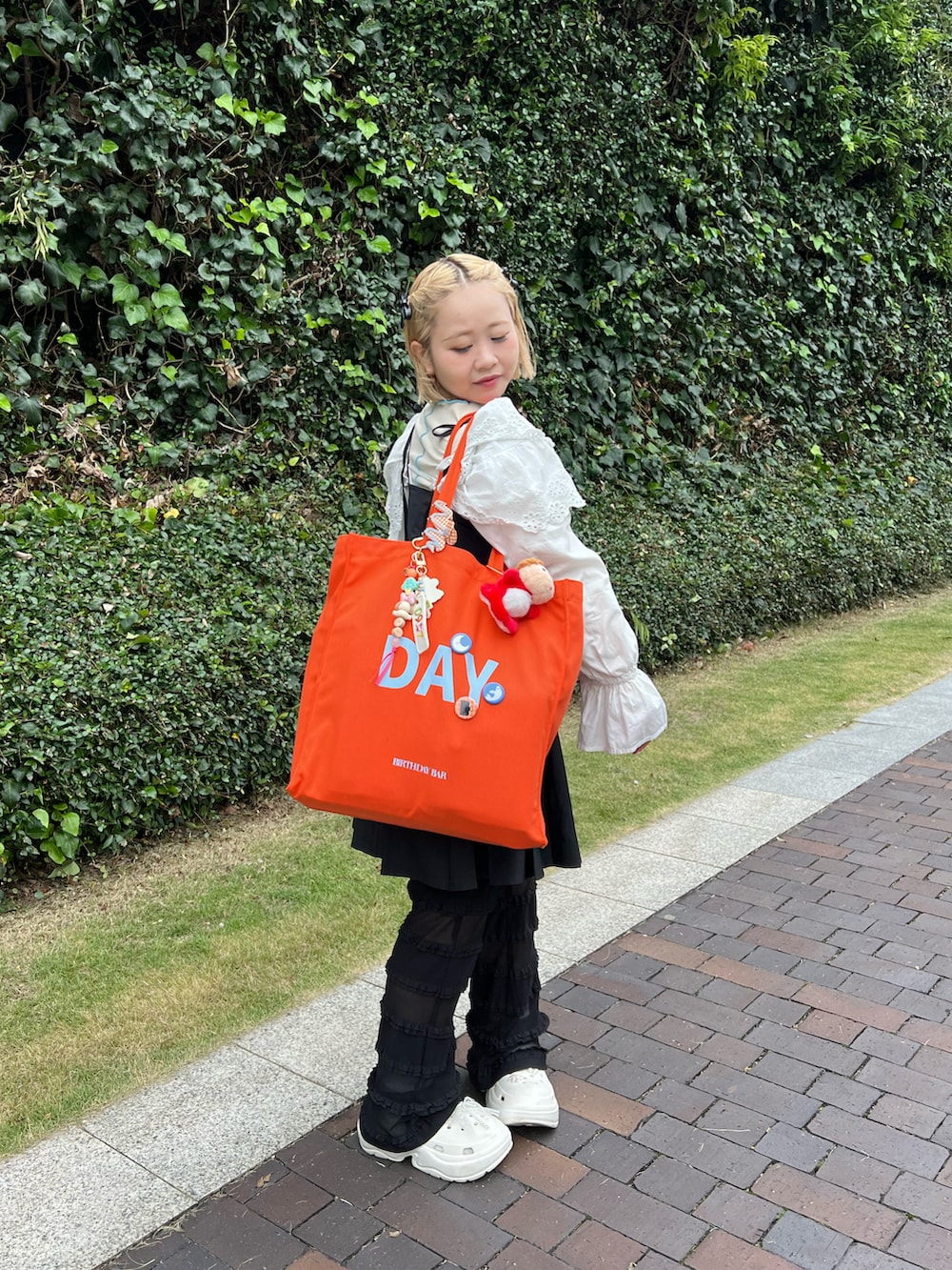 オレンジ系のトートバッグ、その他のその他を着用したレディースの春コーディネートの2枚目の写真