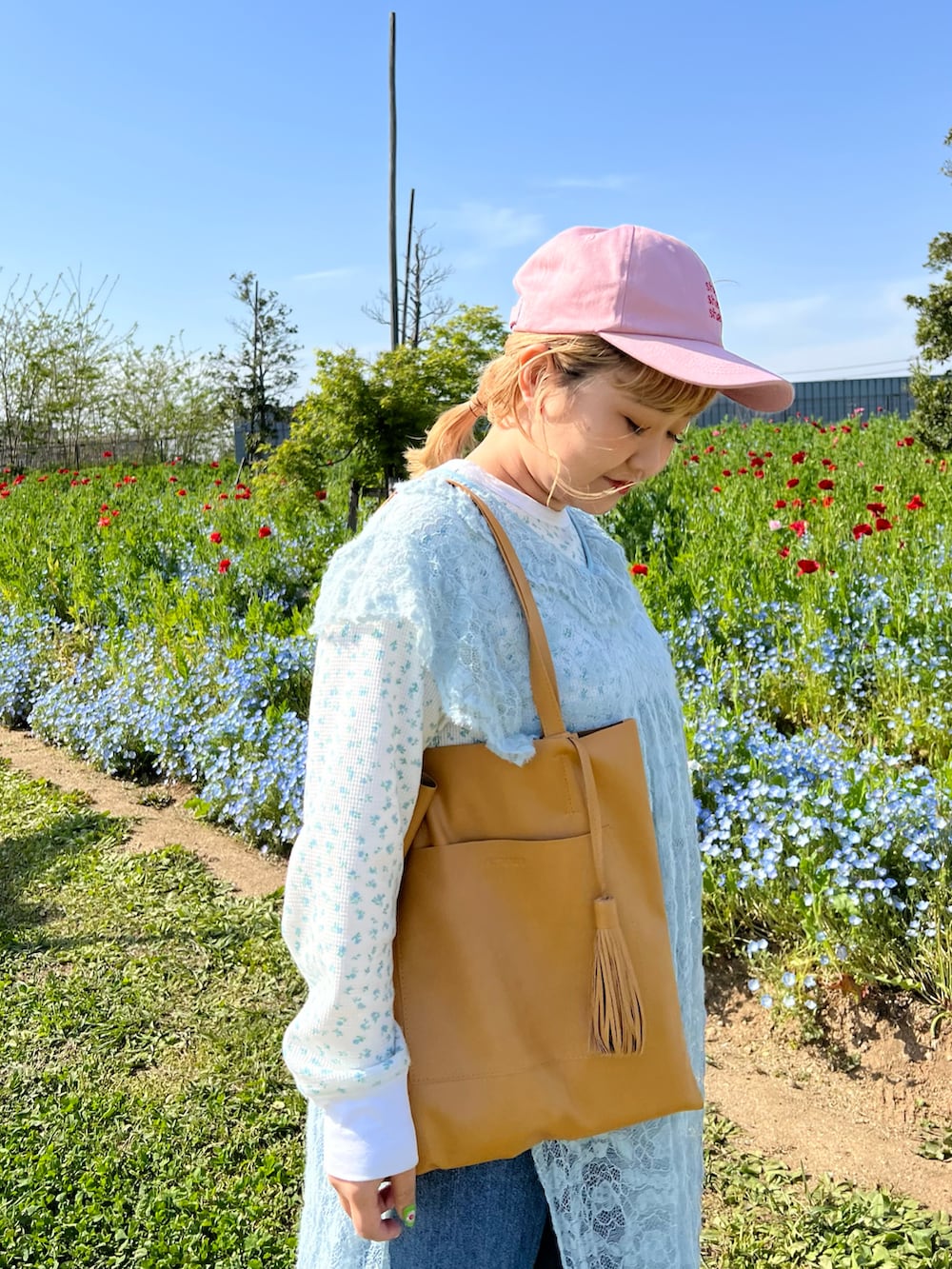 イエロー系のトートバッグ、オレンジ系のスニーカー、ブルー系のTシャツ/カットソーを着用したレディースの春コーディネートの3枚目の写真