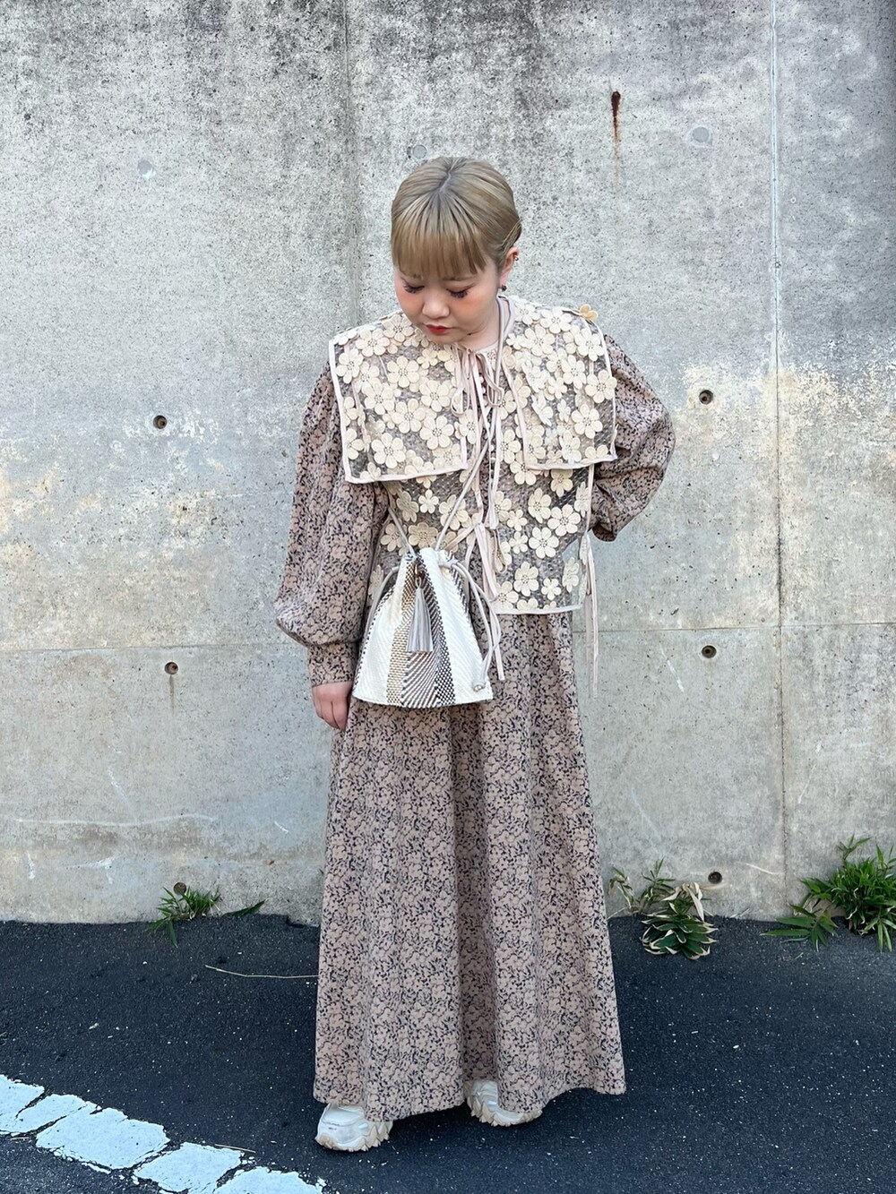 ベージュ系のショルダーバッグ、ベージュ系のベスト、ベージュ系のワンピースを着用したレディースの春コーディネートの2枚目の写真