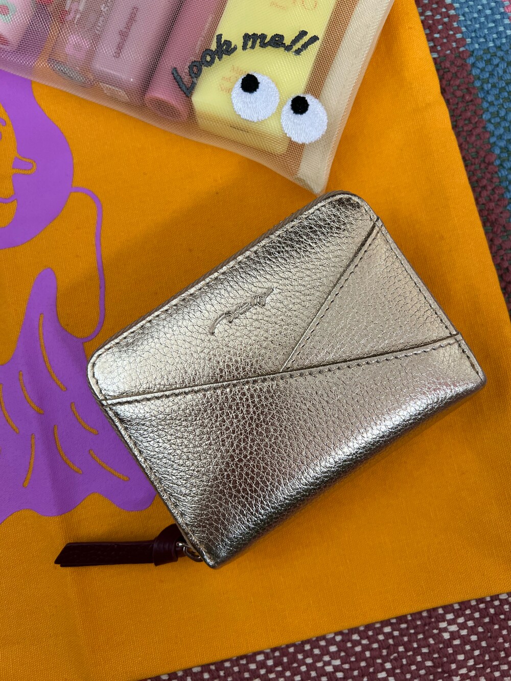 ホワイト系のポーチ、ホワイト系のチャーム、ゴールド系の財布を着用したレディースの夏コーディネートの4枚目の写真