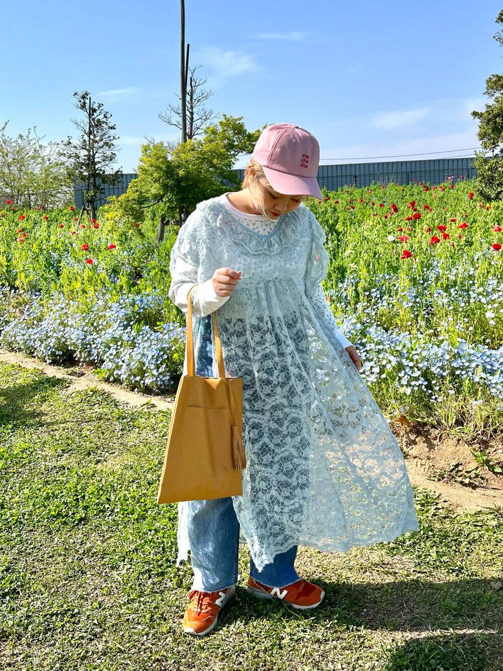 イエロー系のトートバッグ、オレンジ系のスニーカー、ブルー系のTシャツ/カットソーを着用したレディースの春コーディネートの2枚目の写真