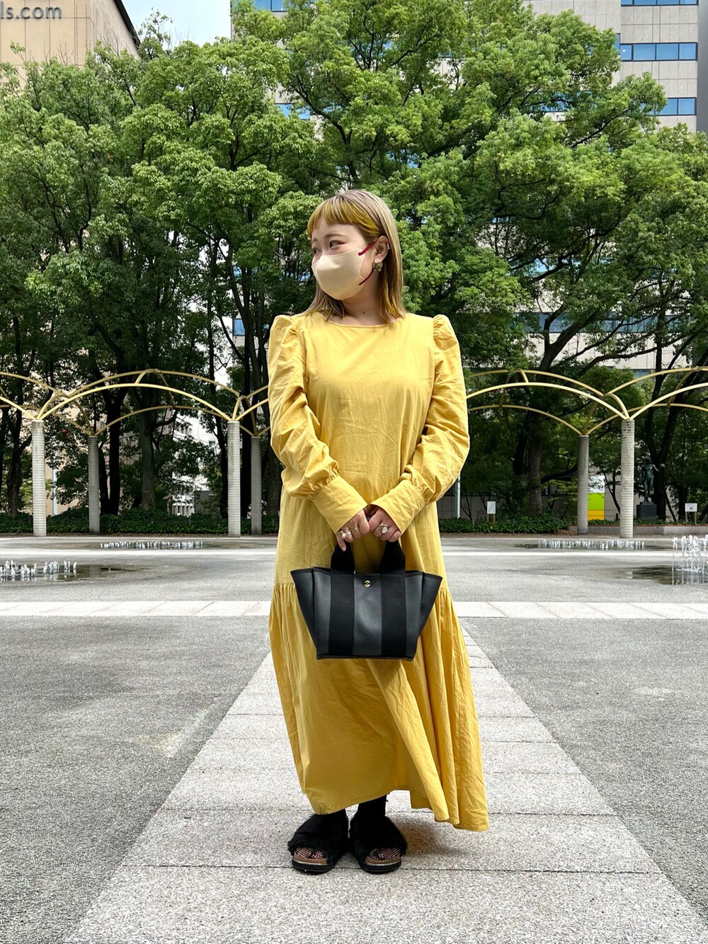 ブラック系のトートバッグ、イエロー系のワンピースを着用したレディースの秋コーディネートの5枚目の写真