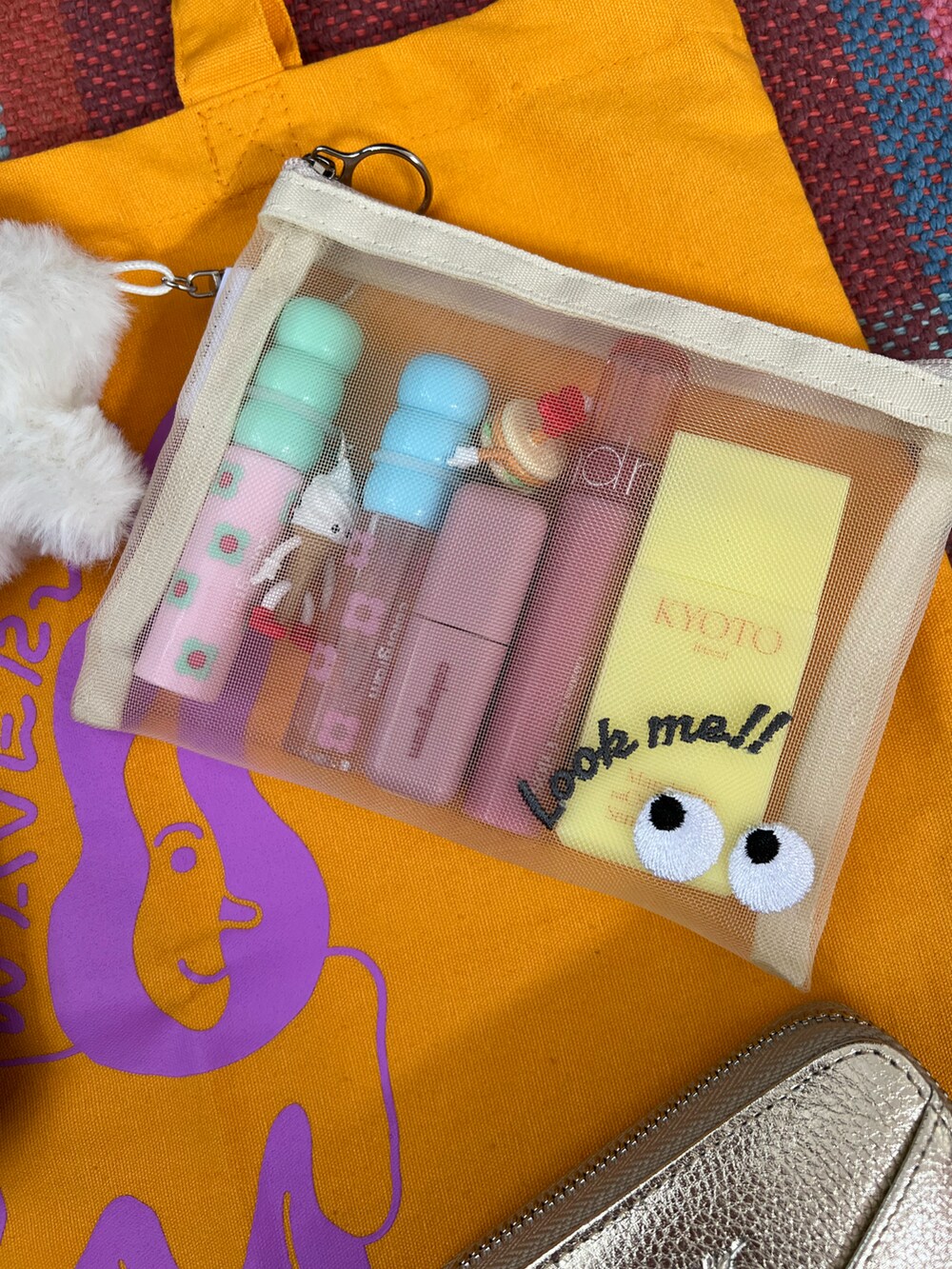 ホワイト系のポーチ、ホワイト系のチャーム、ゴールド系の財布を着用したレディースの夏コーディネートの3枚目の写真