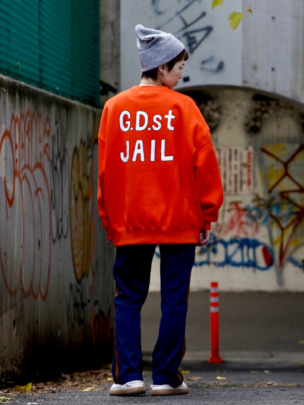 ホワイト系のスリッポン、ブルー系のその他パンツ、オレンジ系のスウェットを着用したレディースの冬コーディネートの2枚目の写真