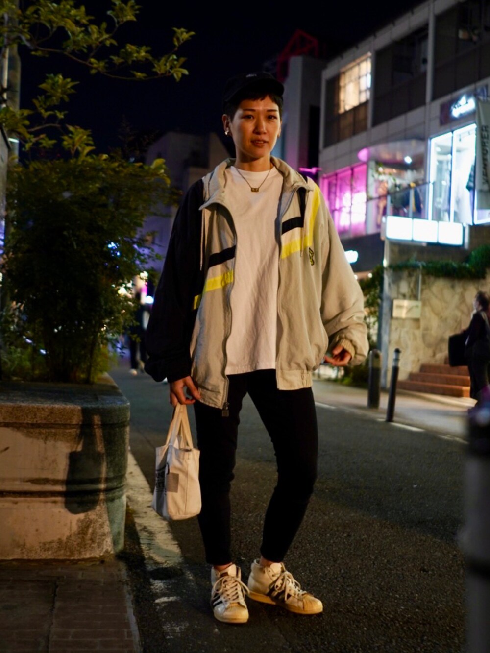 ホワイト系のスニーカー、ブラック系のデニムパンツ、ホワイト系のTシャツ/カットソーを着用したレディースの秋コーディネートの2枚目の写真