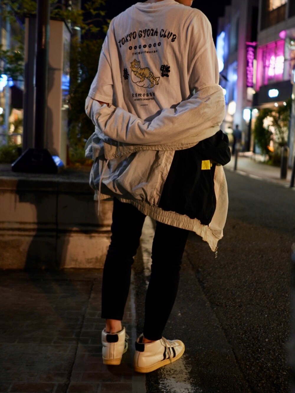 ホワイト系のスニーカー、ブラック系のデニムパンツ、ホワイト系のTシャツ/カットソーを着用したレディースの秋コーディネートの3枚目の写真